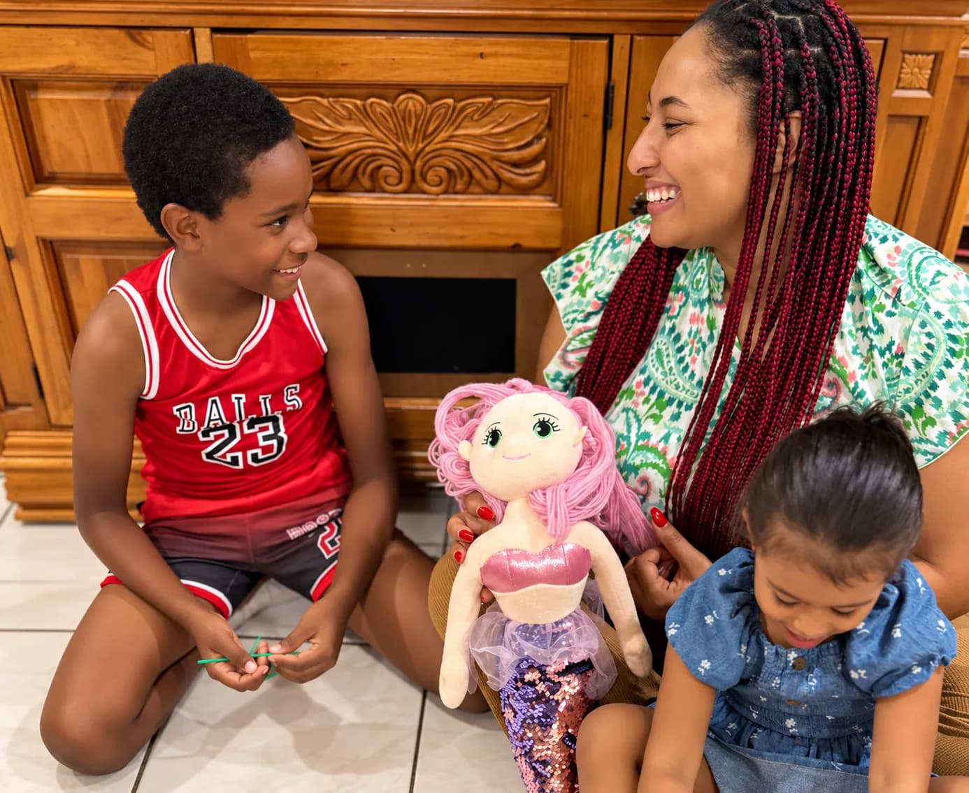 Attentive Angels babysitter laughing and playing with two children at home in Grand Cayman