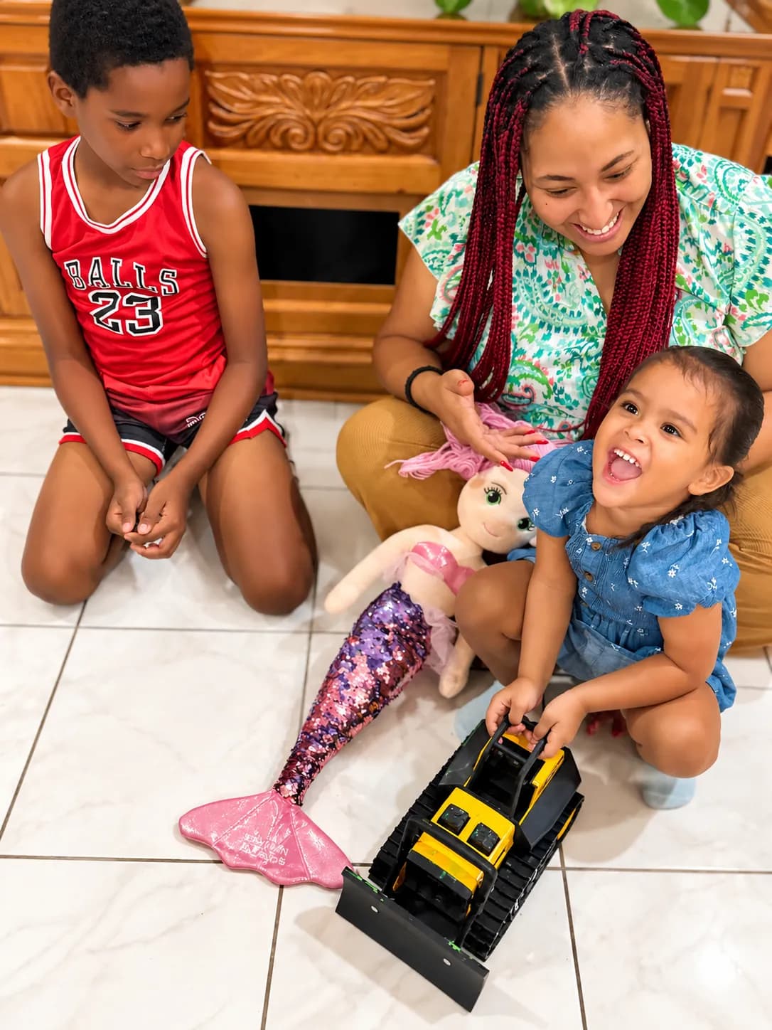 Sitter and children having fun with toys at home in the Cayman Islands